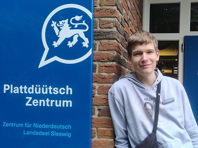 Fiete steht vor dem Eingang zum Plattdüütsch Zentrum.